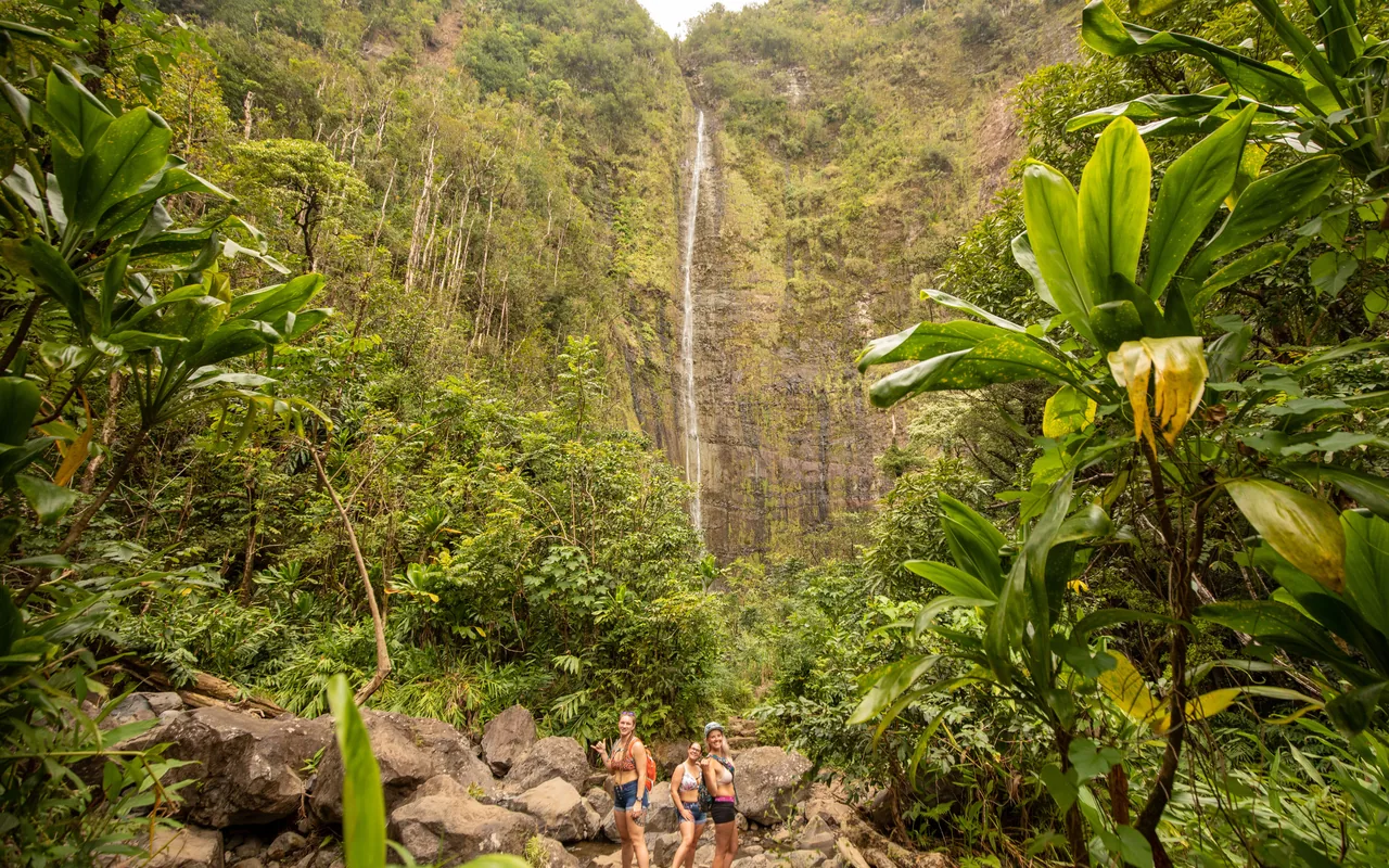 Guests standing beneath Waimoku Falls on the Pipiwai Trail