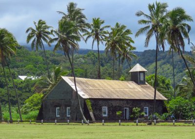 Historic stone church surrounded by palm trees in East Maui