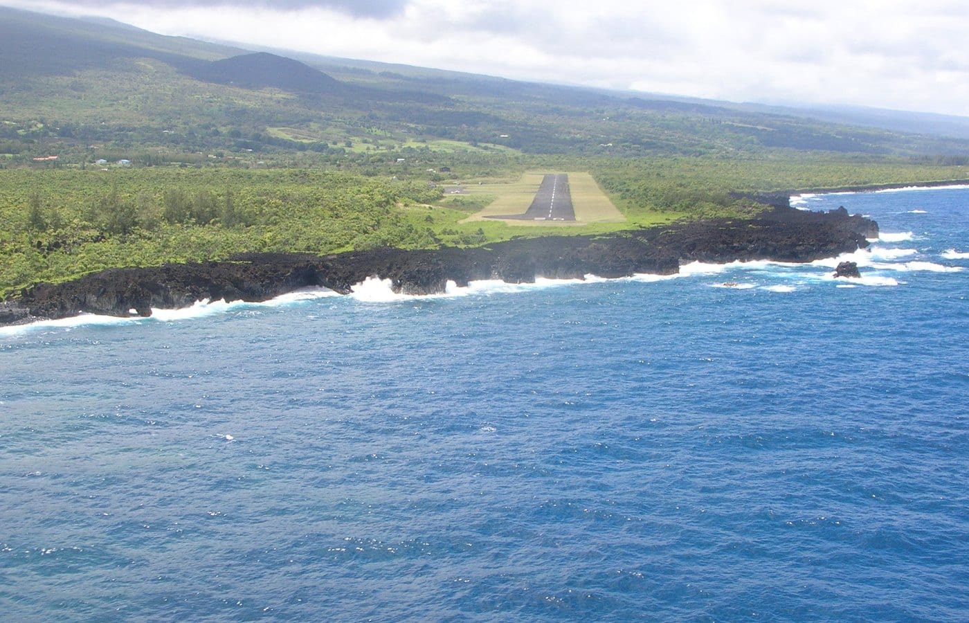 Aerial view of Hāna Airport runway, lava shoreline, and open ocean