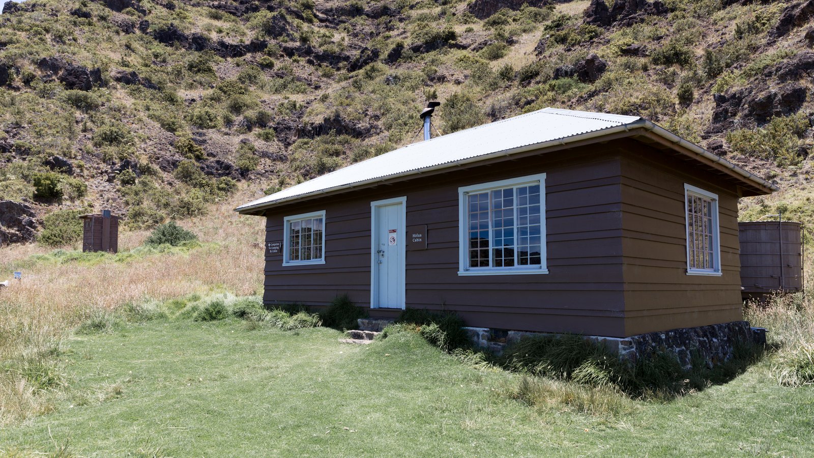 Hōlua Cabin beneath the rocky wall of the Haleakalā summit depression
