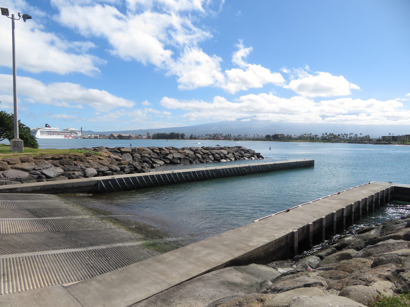Paddlers and boats at Kahului Harbor with a cruise ship across the basin