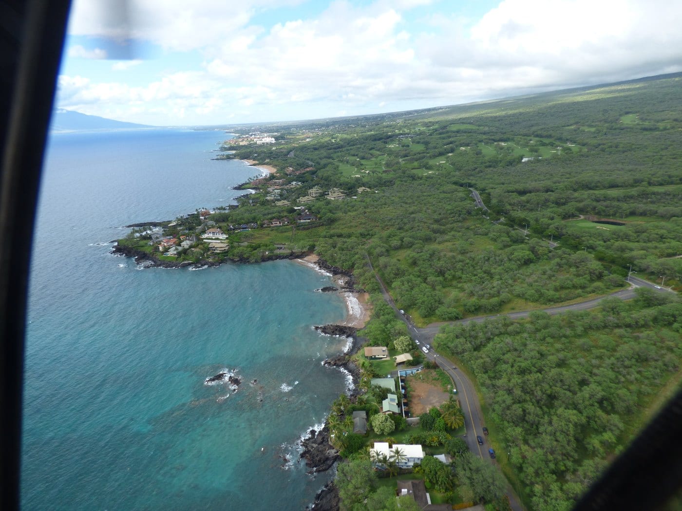 Aerial view along the rocky shoreline and small cove at Mākena Landing