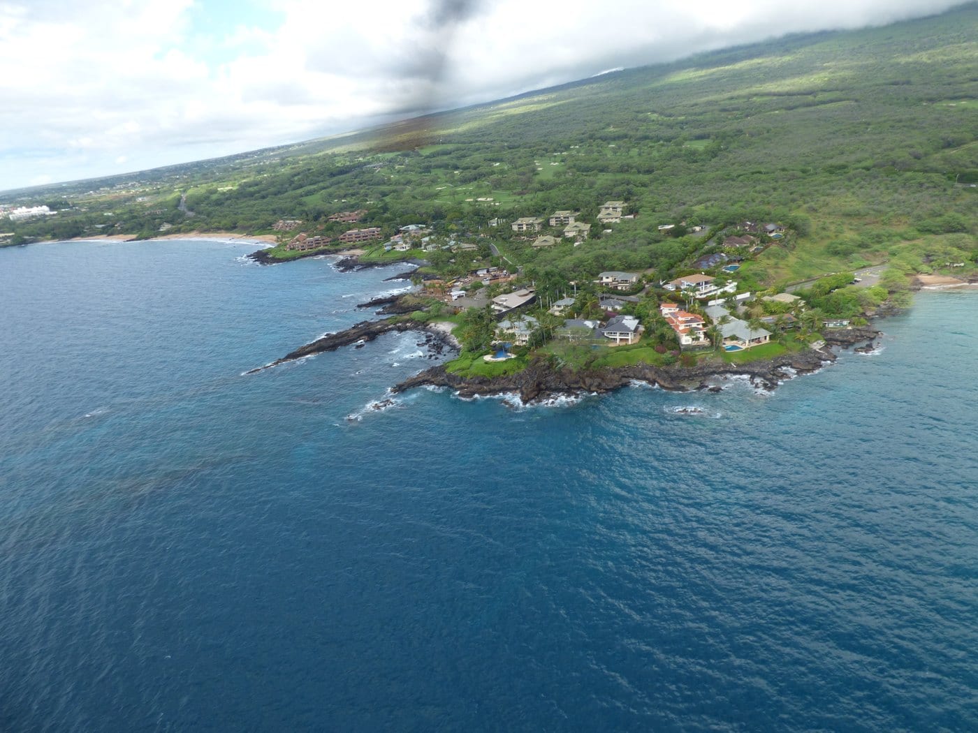 Aerial view of a rocky point and clear water near Mākena Landing