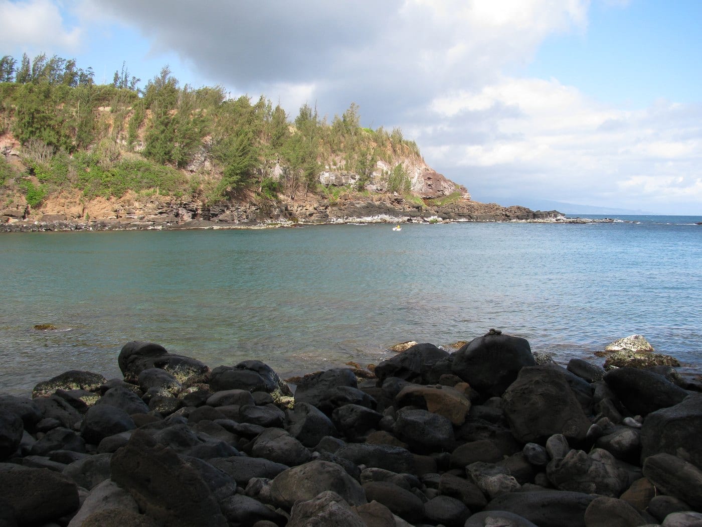 Small boat on calm water inside Māliko Bay in 2010