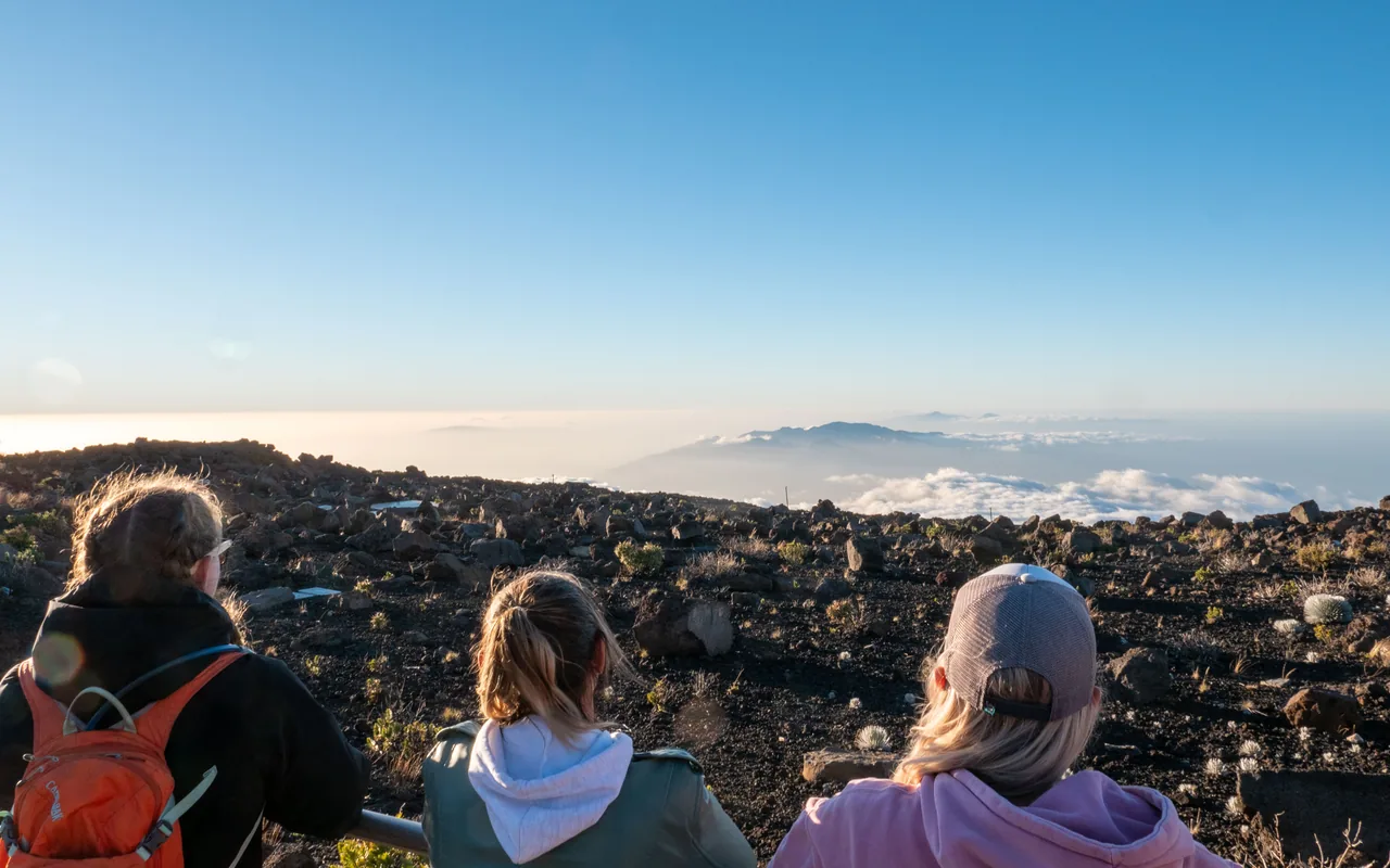 Guests looking across Haleakalā’s summit landscape above the clouds